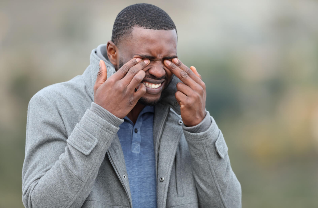 A person pressing his eyes due to pain.