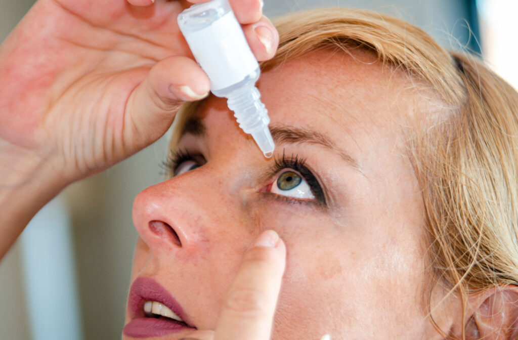 A woman in her 40s putting vuity eye drops in her eye to help with presbyopia.