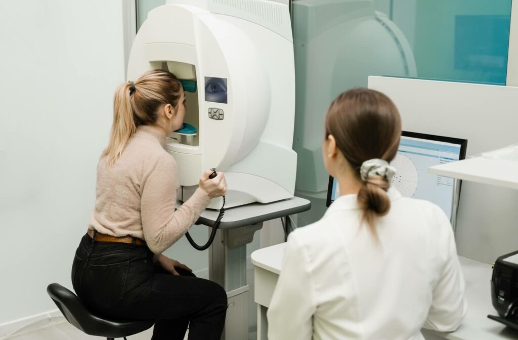 An eye doctor guides a patient through a visual field test.
